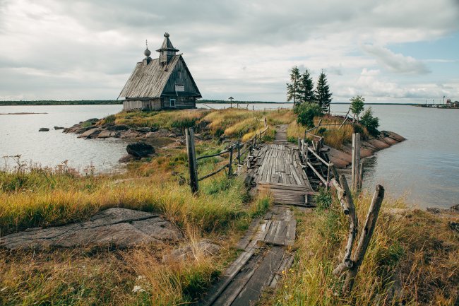 Old russian Orthodox wooden church in the village Rabocheostrovsk, Karelia. Abandoned church on the coastline.