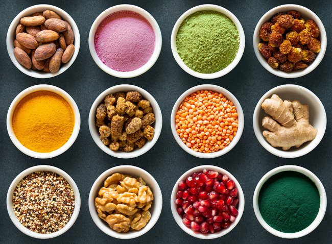 Various colorful superfoods as acai powder, turmeric, matcha gre